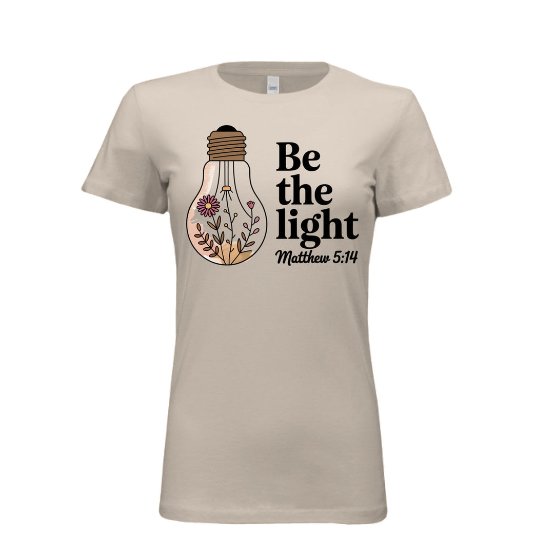 Women's fitted tee in soft cream with a floral light bulb graphic and the words “Be the light – Matthew 5:14” in bold and script fonts.