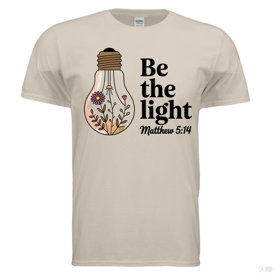 Sand Christian t-shirt with floral light bulb graphic and bold black text reading ‘Be the light – Matthew 5:14’