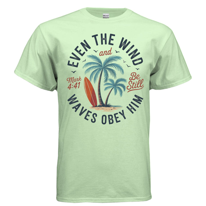 Mint green Christian t-shirt with palm trees, a red surfboard, and the words ‘Even the wind and waves obey Him – Mark 4:41’ and ‘Be Still’