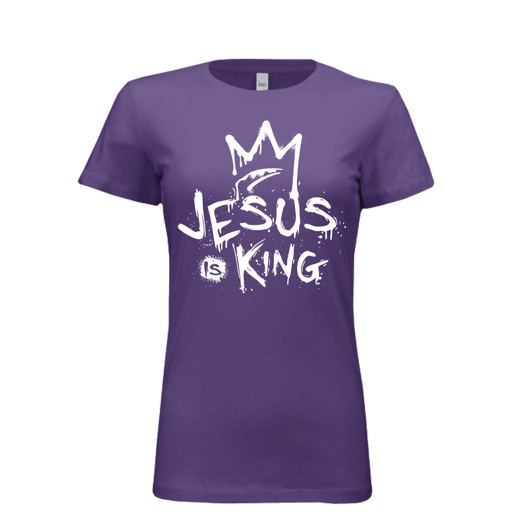 Purple women’s fitted t-shirt with bold white graffiti-style design reading “Jesus Is King” under a crown. Urban faith statement piece.