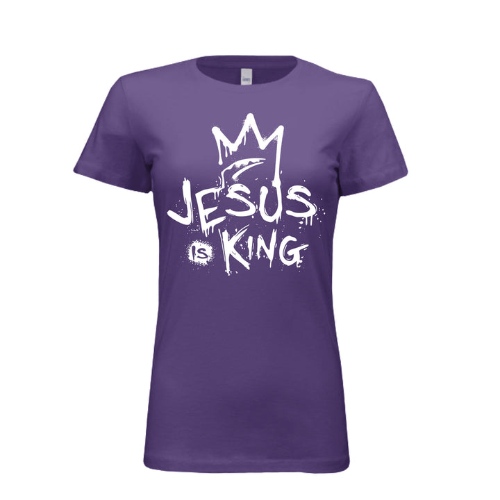 Purple women’s fitted t-shirt with bold white graffiti-style design reading “Jesus Is King” under a crown. Urban faith statement piece.