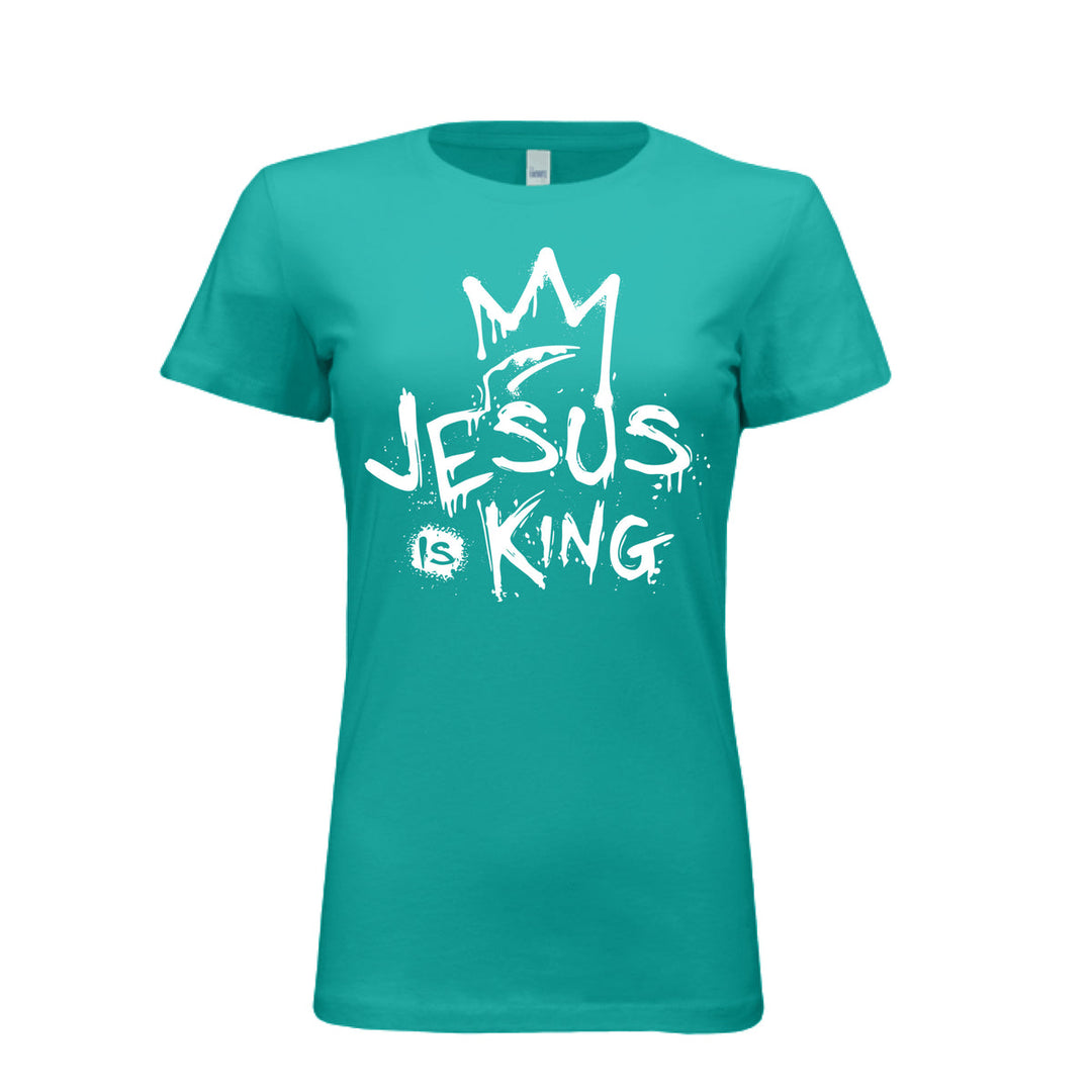 Teal women’s fitted t-shirt with bold white graffiti-style design reading “Jesus Is King” under a crown. Urban faith statement piece.