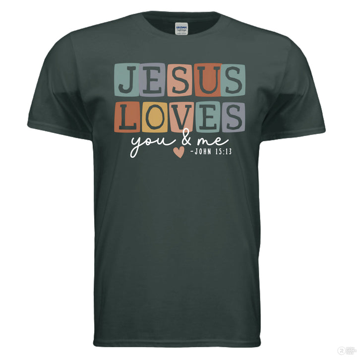 Forest green shirt with pastel block letters reading “Jesus Loves You & Me” and a heart, referencing John 15:13.