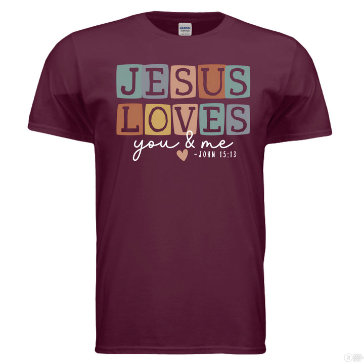 Maroon shirt with pastel block letters reading “Jesus Loves You & Me” and a heart, referencing John 15:13.