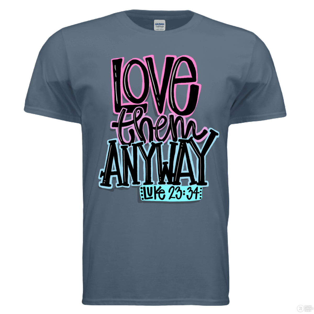 Indigo blue Christian tee with bold lettering in pink, black, and blue that reads “Love them anyway” with scripture reference Luke 23:34